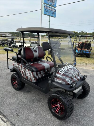 Custom lifted golf cart with red rims and Gamecocks graphics parked outside Jimmy’s Carolina Carts in Florence, South Carolina