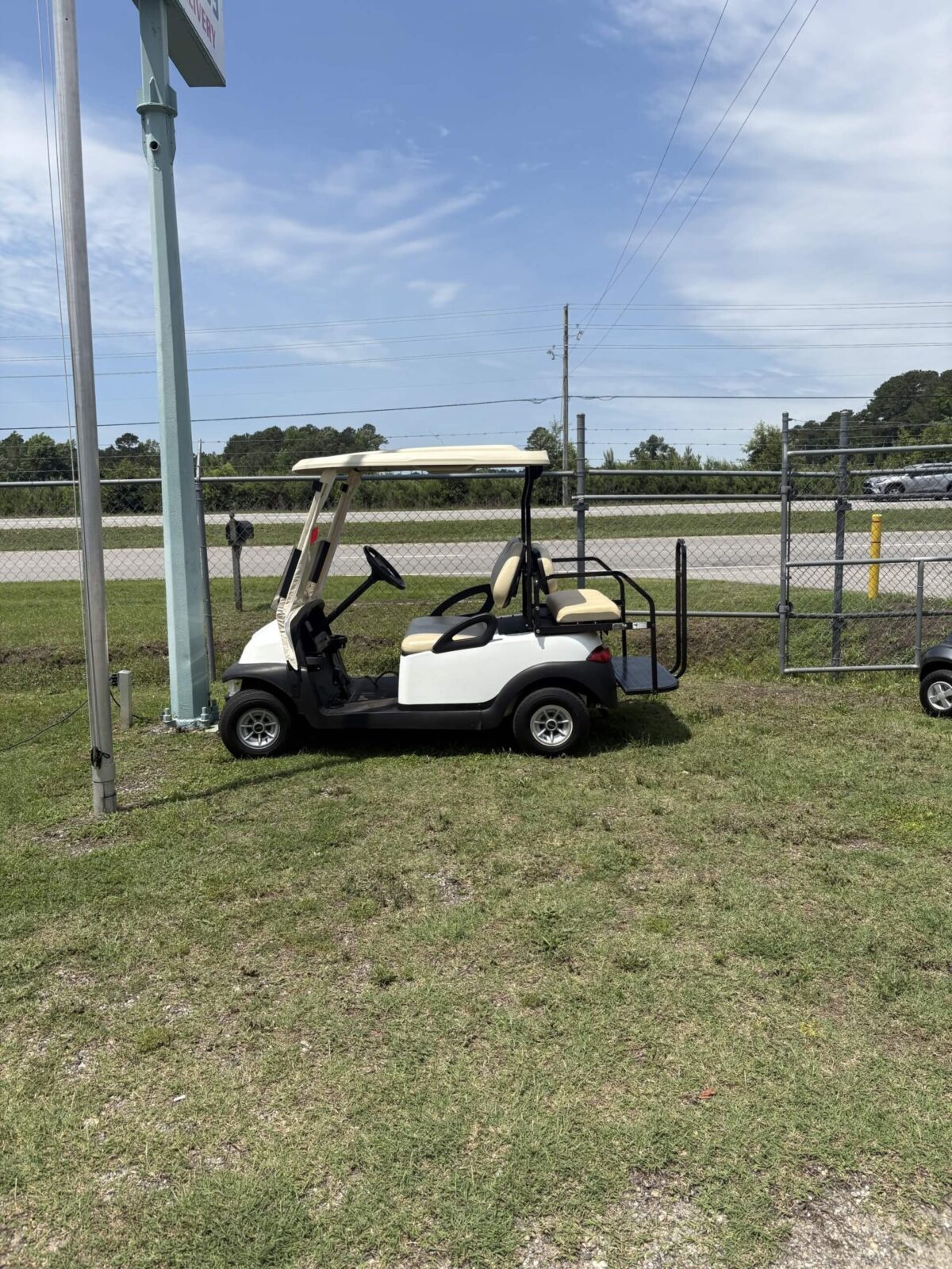 2011 Club Car Precedent golf cart in white with beige seats, rear flip seat, and cargo platform displayed at Jimmy's Carolina Carts in Florence, South Carolina.