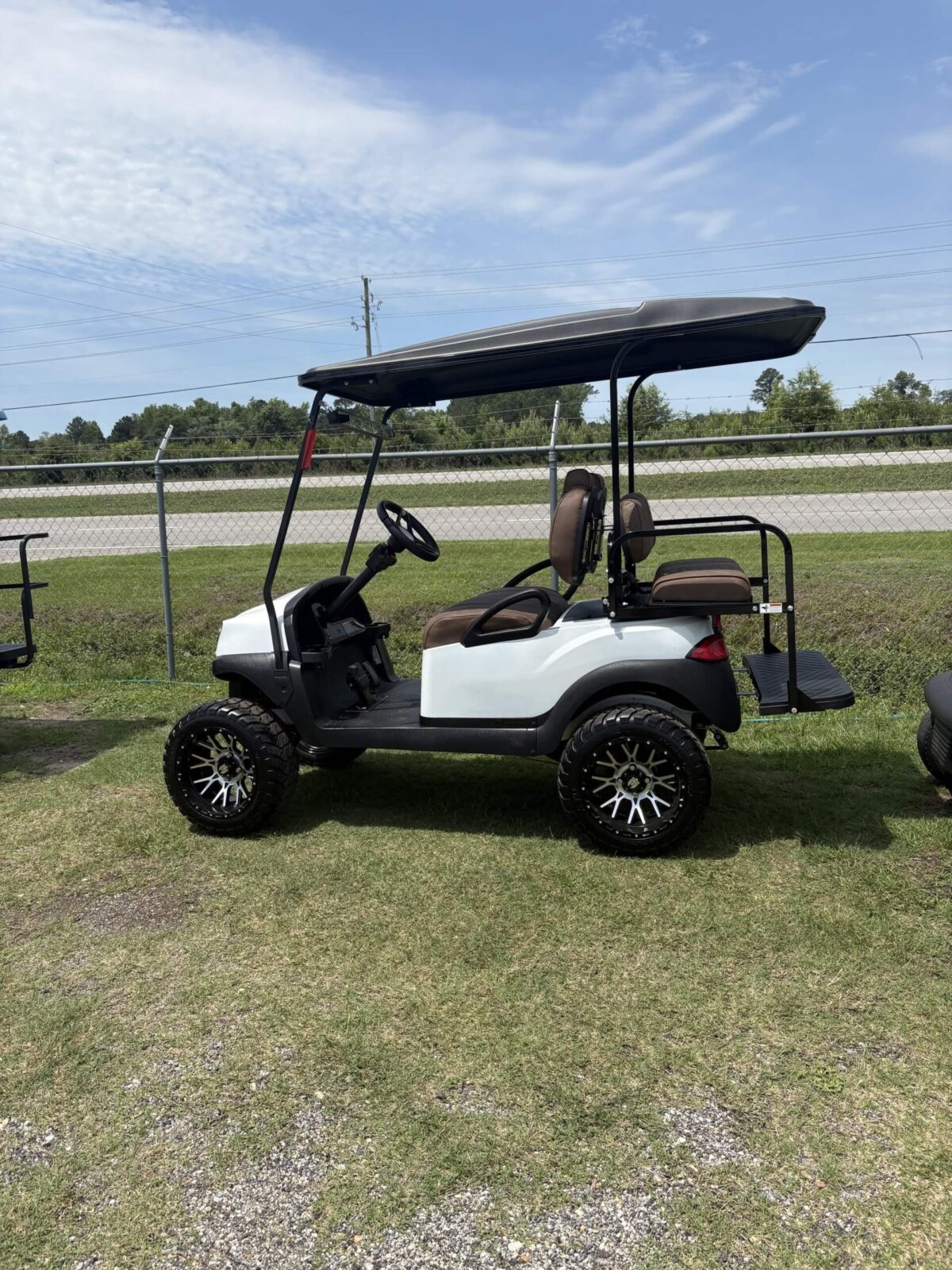 2020 Club Car Tempo gas golf cart in white with brown premium seats, lifted suspension, custom wheels, and rear flip seat displayed at Jimmy's Carolina Carts in Florence, South Carolina.